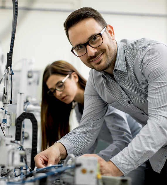 Eine Frau und ein Mann prüfen ein elektronisches Gerät.